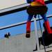 Reflected in the window, a man photographs from the top of a parking garage as Superman scales the side of C.S. Mott Children's Hospital on Monday, June, 3, 2013. Melanie Maxwell I AnnArbor.com